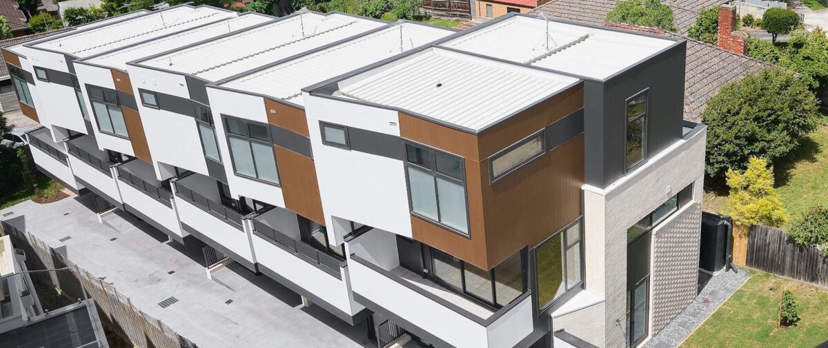 Aerial view of a multi-unit townhouse development on a sloping block