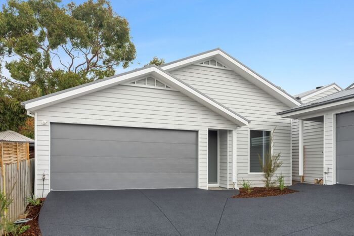 Single-level unit facade with double garage in a Kilsyth sloping block development