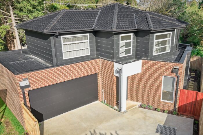 Double-storey dual-occupancy family home with brick facade and garage in Croydon