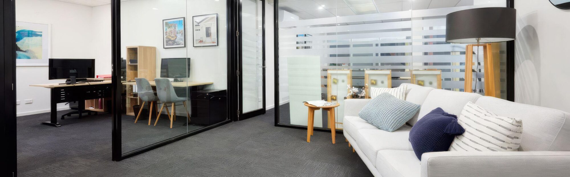 Commercial office fit-out with glass partitions, lounge seating and private work areas